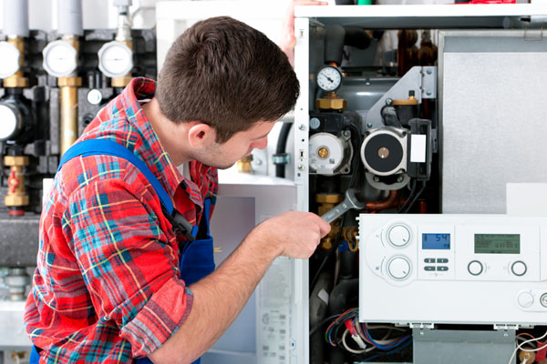 Heating technician repairing boiler controls in Newark