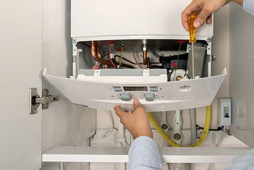 Heating technician repairing a residential boiler in Newark