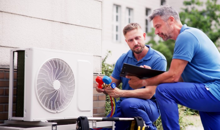 HVAC technicians installing an outdoor air conditioning unit in Newark